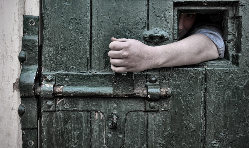 Arm reaches through jail window to open door escape scene